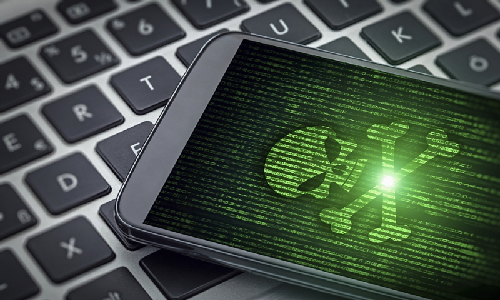Phone with Skull on Screen on top of Laptop Keyboard