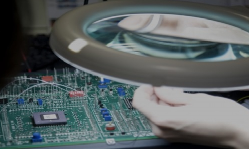 Researcher Looking at Microchip Board through Magnifying Lense