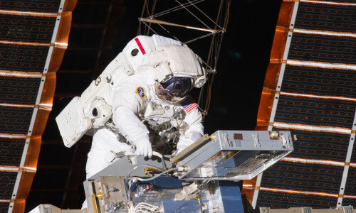 Astronaut outside of space station wearing spacesuit