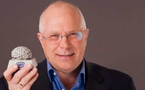 John Granacki holding a brain model in his hand