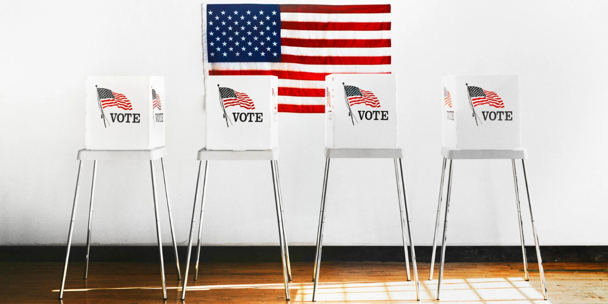 Photograph of a voting booth in front of a USA flag