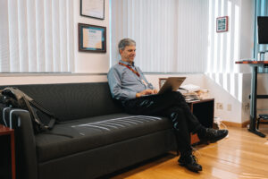 Person seating on office couch typing on computer
