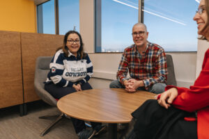 People seated around round coffee table chatting