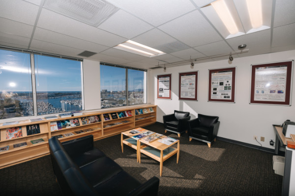 Lobby of ISI MDR building with sofas and coffee table with journals next to windows overlooking the marina